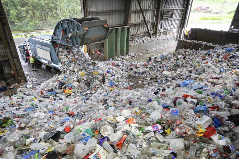 a truck dumps its contents of recyclable items on the tipping floor at the Town of Brookhaven Material Recycling Facility in Yaphank, N.Y., on Aug. 30, 2023.