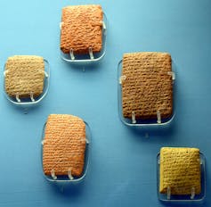 Five stone tablets against a blue background