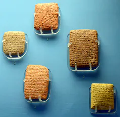 Five stone tablets against a blue background