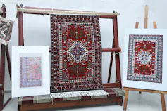 red woven carpet hanging on stand