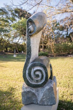 An abstract sculpture with a spiral at the base.