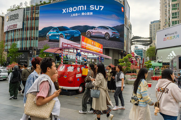 A rua de pedestres Chunxi Road está repleta de jovens vestidos de acordo com a moda.