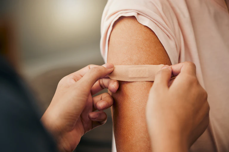 A bandaid is placed on a person's upper arm.