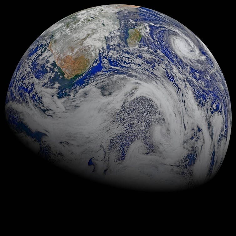 The Earth seen from space, covered in patches of white cloud.