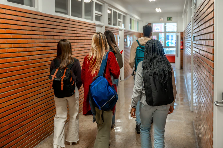 A group of university students walk down the hallway