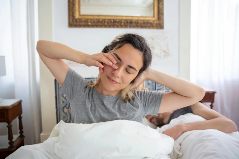 Woman stretches after waking to daylight