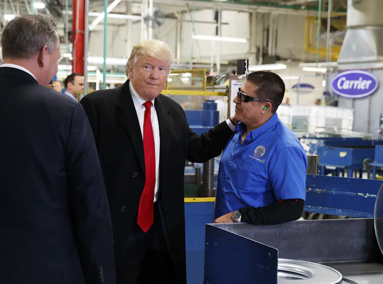 man in suit greets factory worker