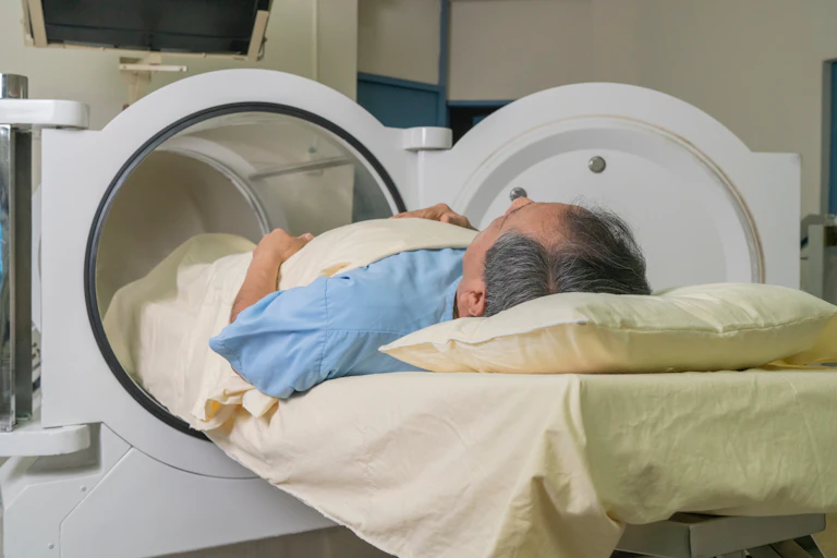 Back view of man lying down read to enter hyperbaric chamber.