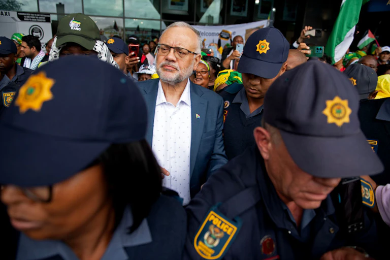 A man surrounded by people in police uniform