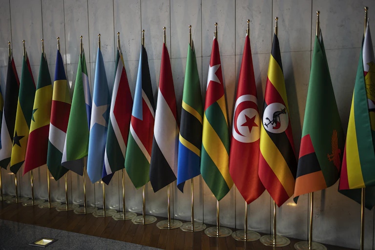 A group of flags standing against a wall