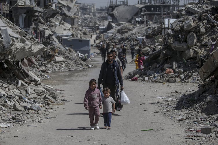 International Affairs Briefing: International considers reaction to Trump’s price lists – and Israel launches new Gaza offensive 2 Palestinians walk past the rubble of destroyed buildings.