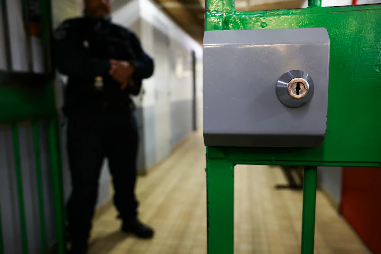 Un agent pénitentiaire se tient derrière une porte ouverte à la Maison d'arrêt des Hauts-de-Seine, à Nanterre, en banlieue parisienne, le 30 novembre 2024.