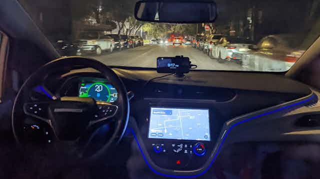 interior of a car driving at night with no one at the wheel