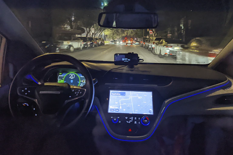 interior of a car driving at night with no one at the wheel