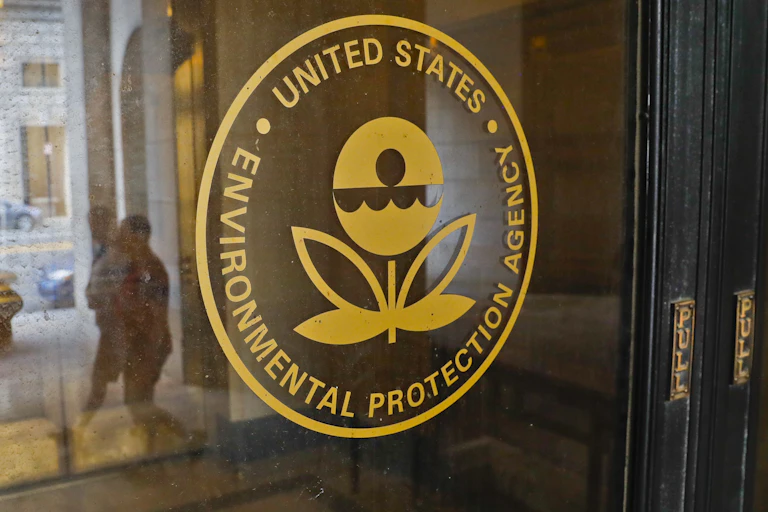 The EPA logo on a door with people reflected in the glass.
