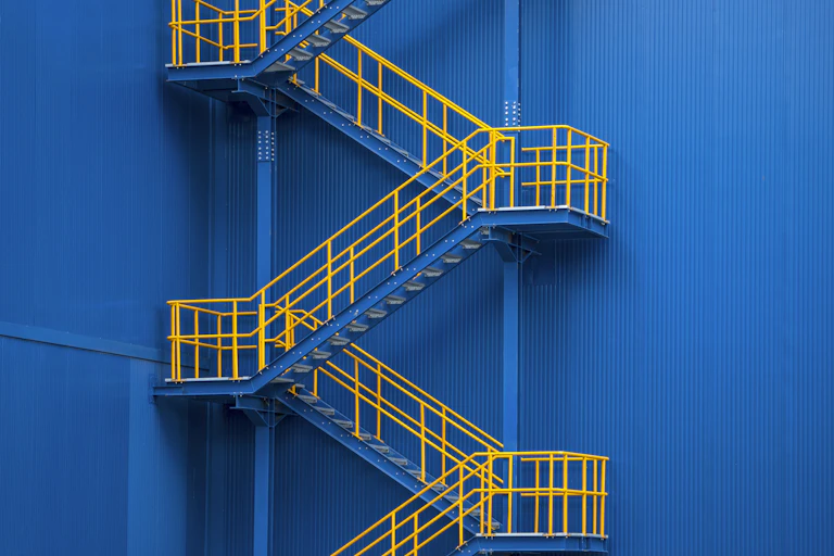 yellow staircases zigzag against a blue wall