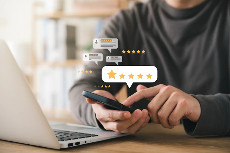 A person uses a cell phone while images of star ratings float around them