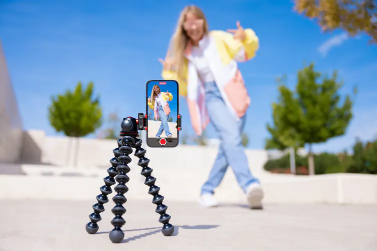 Teenage girl filming video of herself on mobile phone.