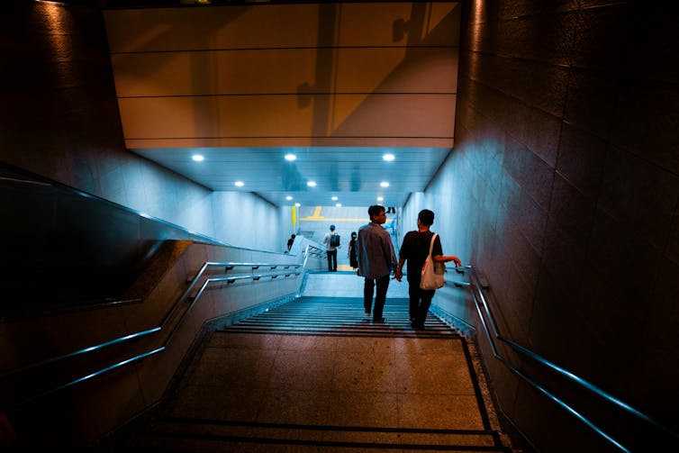A couple walks on the subway stairs