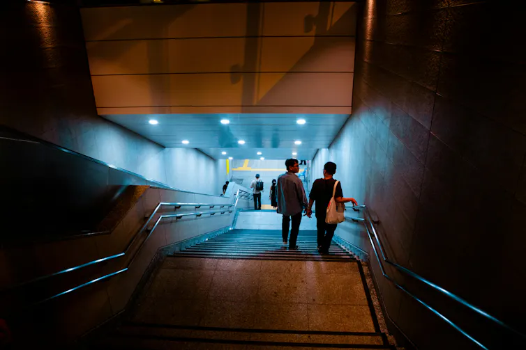 A couple walks down subway stairs