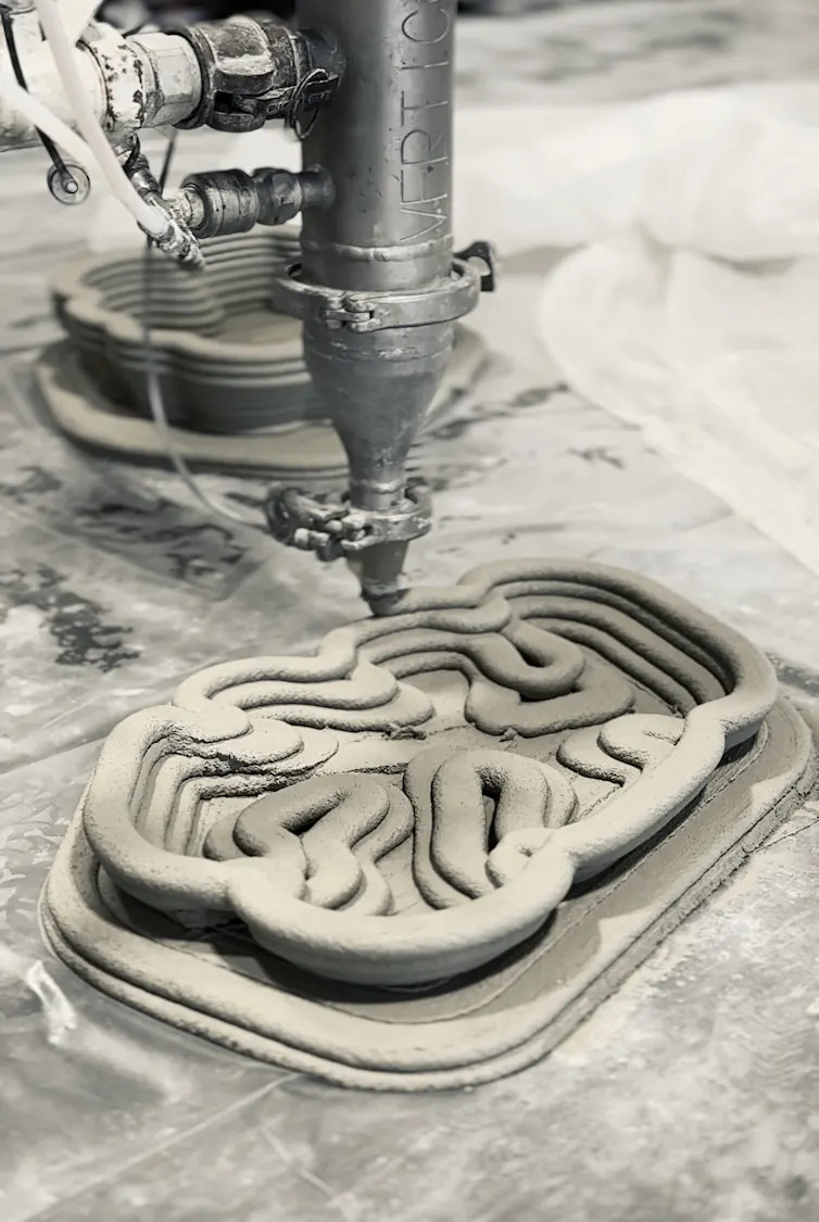 Metal machine above grey swirling multi-layered form
