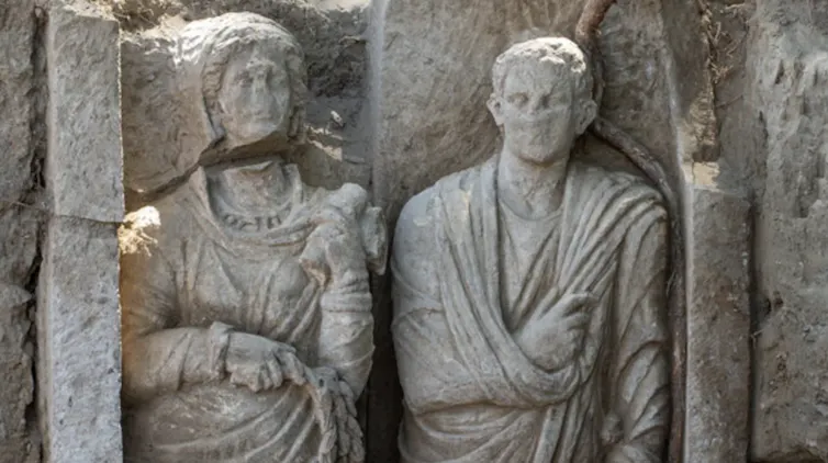 Close up of the faces of the statues, showing that the woman is taller.
