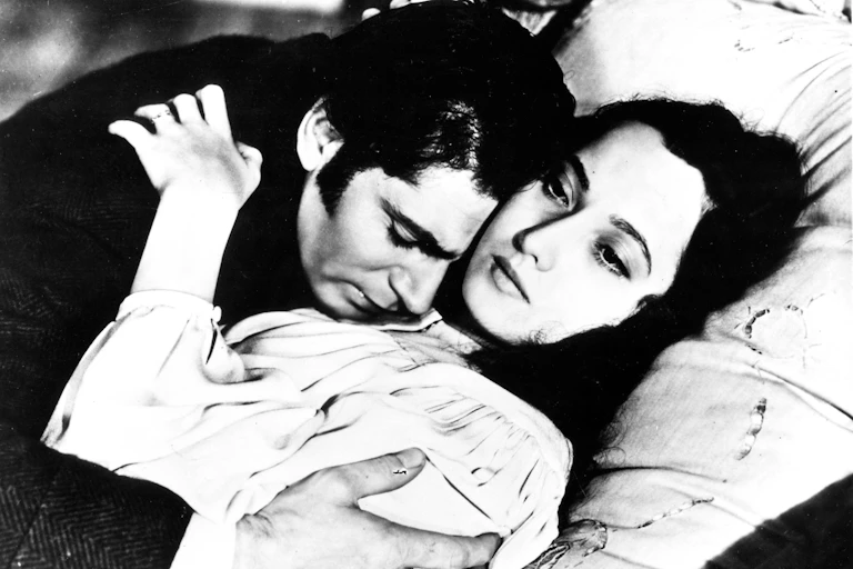 Heathcliff and Cathy clutching each other in bed.