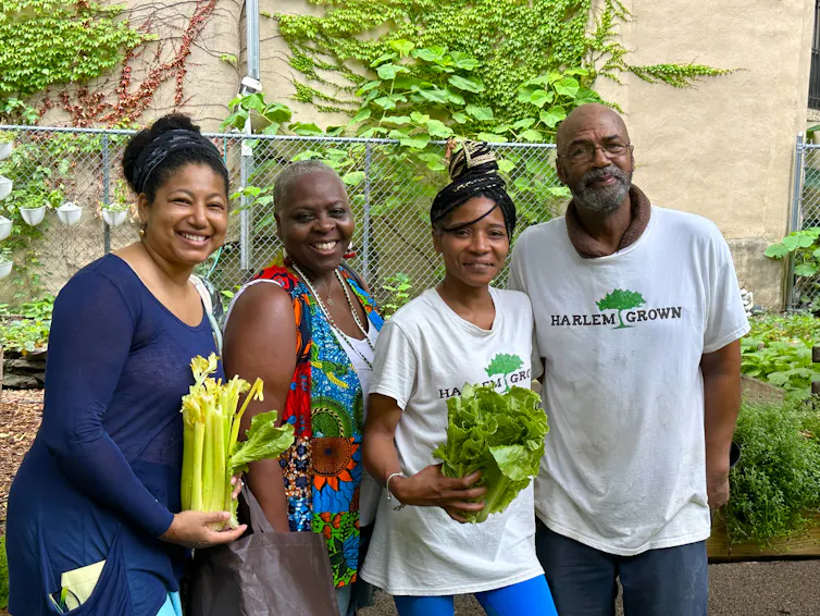 four black growers holding veg and fresh produce