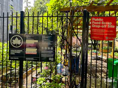 community garden black fence with sign re public food scrap drop-off site