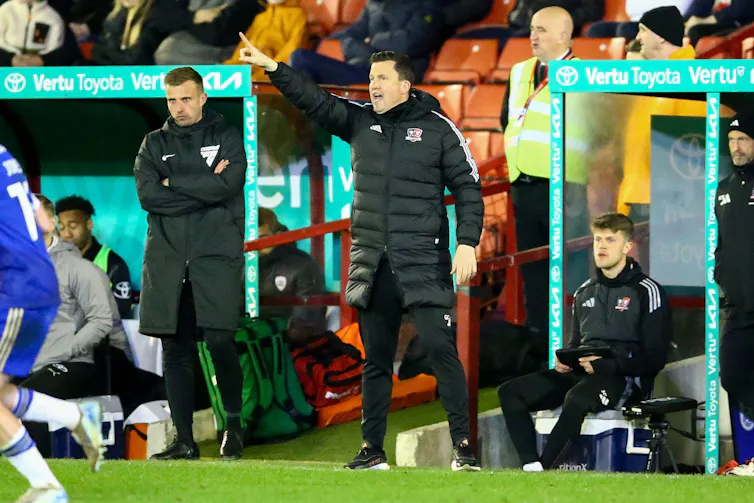 Gary Caldwell in a black puffy coat, shouting and pointing from the side of the pitch