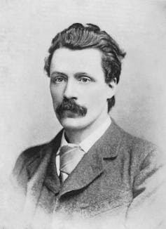 Black and white photo of a man with a bold moustache.