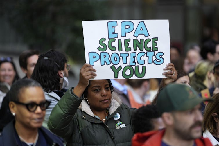 Workers hold a sign reading