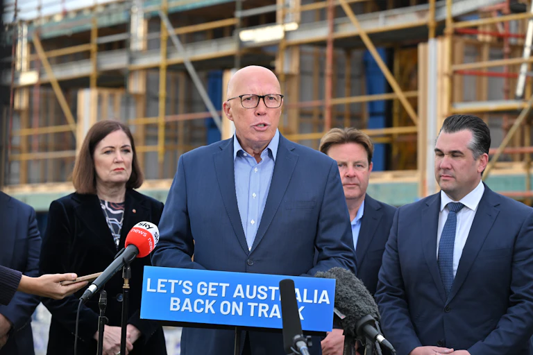 Opposition Leader Peter Dutton speaks at a lectern opposite a building site.