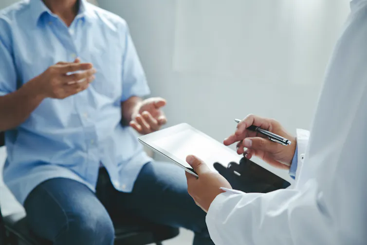 male patient sitting talking to a doctor