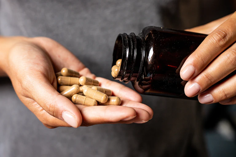 Hand holding capsules of ashwagandha