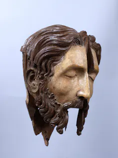 A fragment of a statue of Jesus's head, eyes closd