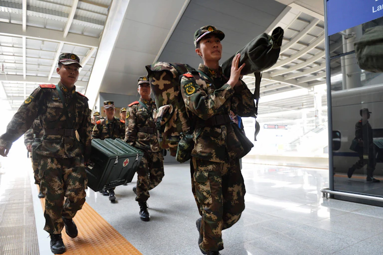Soldiers carrying a box with a red cross on it.