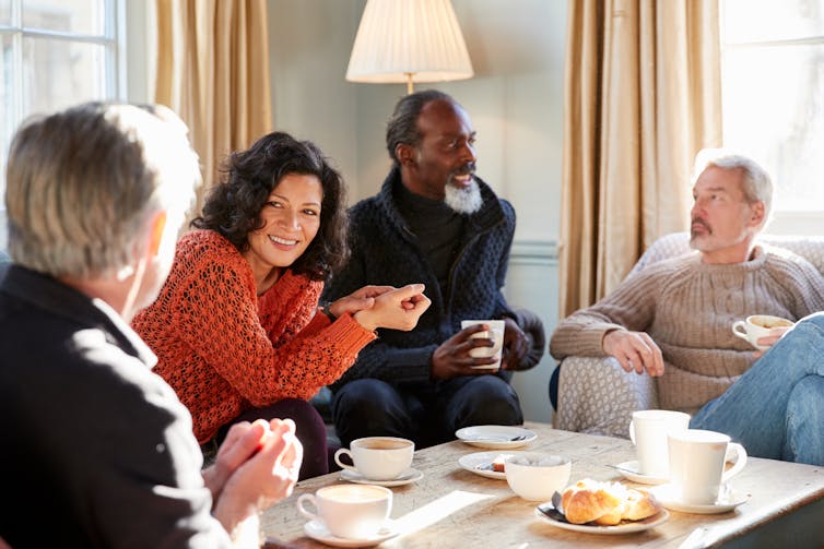 A group of middle-aged adults sitting around a coffee table
