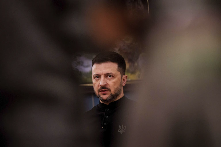 A man's face framed by blurry objects on either side.