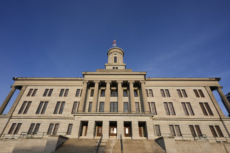 A large granite building of three stories with a tower.