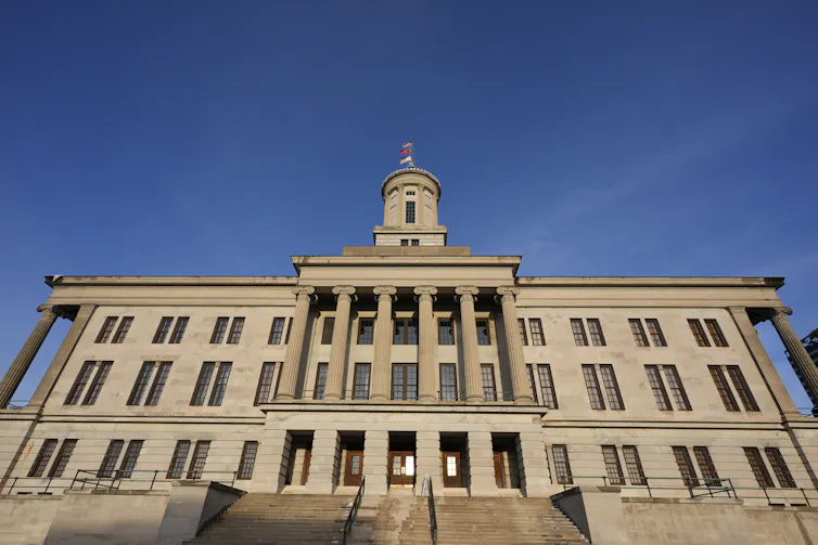 A large granite building of three stories with a tower.