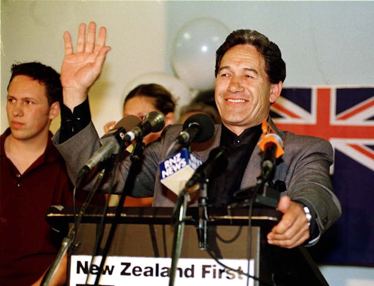 Winston Peters waving from a podium at an election night event.