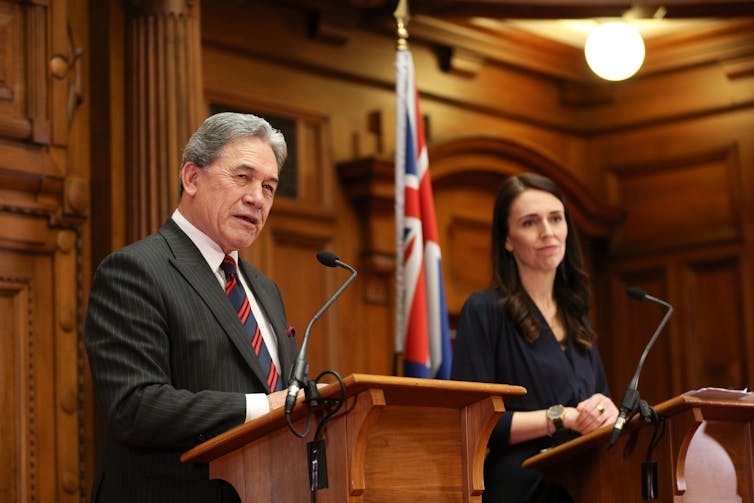 Winston Peters and Jacinda Ardern at podiums.