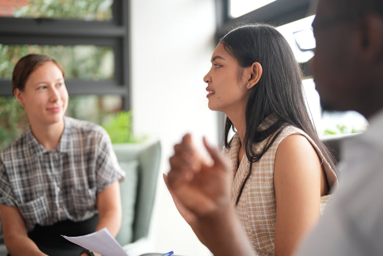 Young adults speak to each other in a circle.