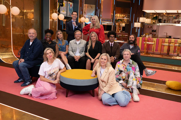 A group of British comedians pose for the camera.