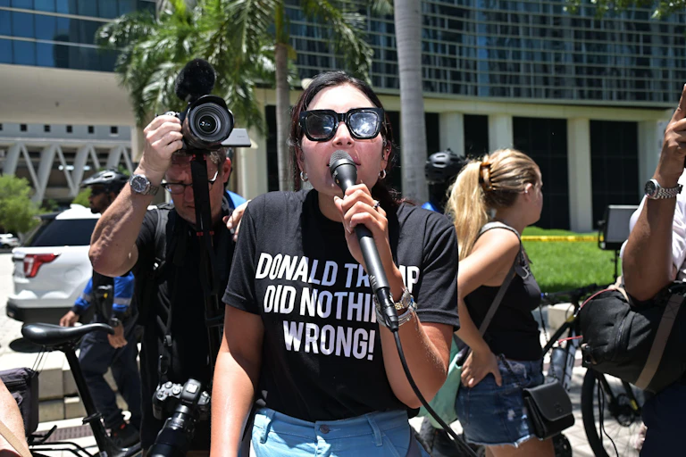 Laura Loomer wearing a t-shirt that reads 'Donald Trump did nothing wrong' at a pro-Trump rally in Miami.