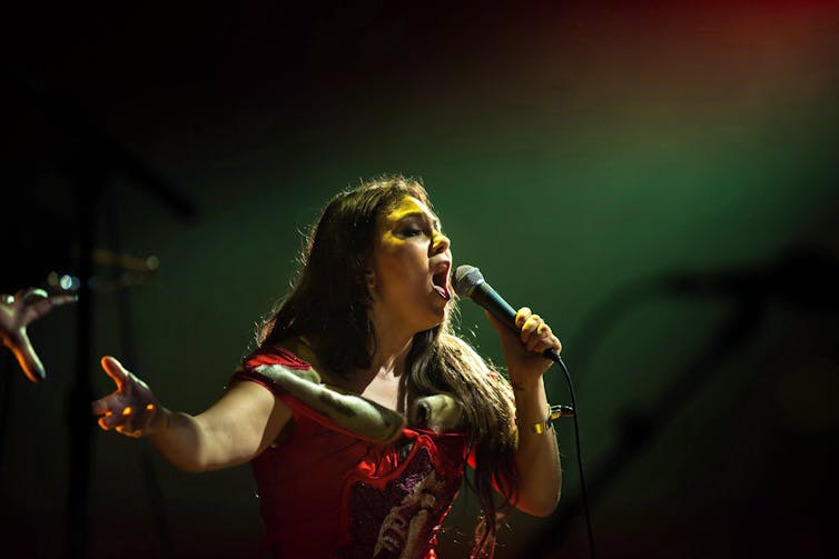 Una mujer sosteniendo el micrófono.