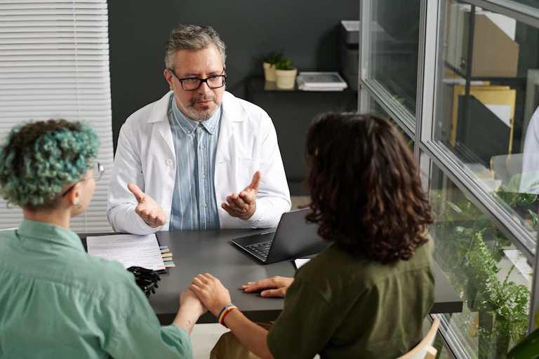 Two people are sitting in a doctor's office.