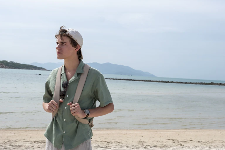 American-British actor, Sam Nivola, on a beach in the season three finale of The White Lotus.