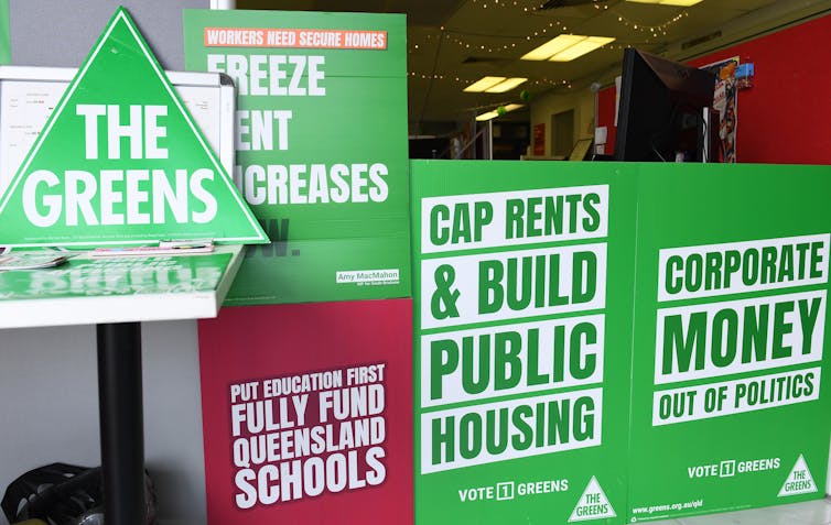 Green signs for The Greens party saying cap rents and build public housing